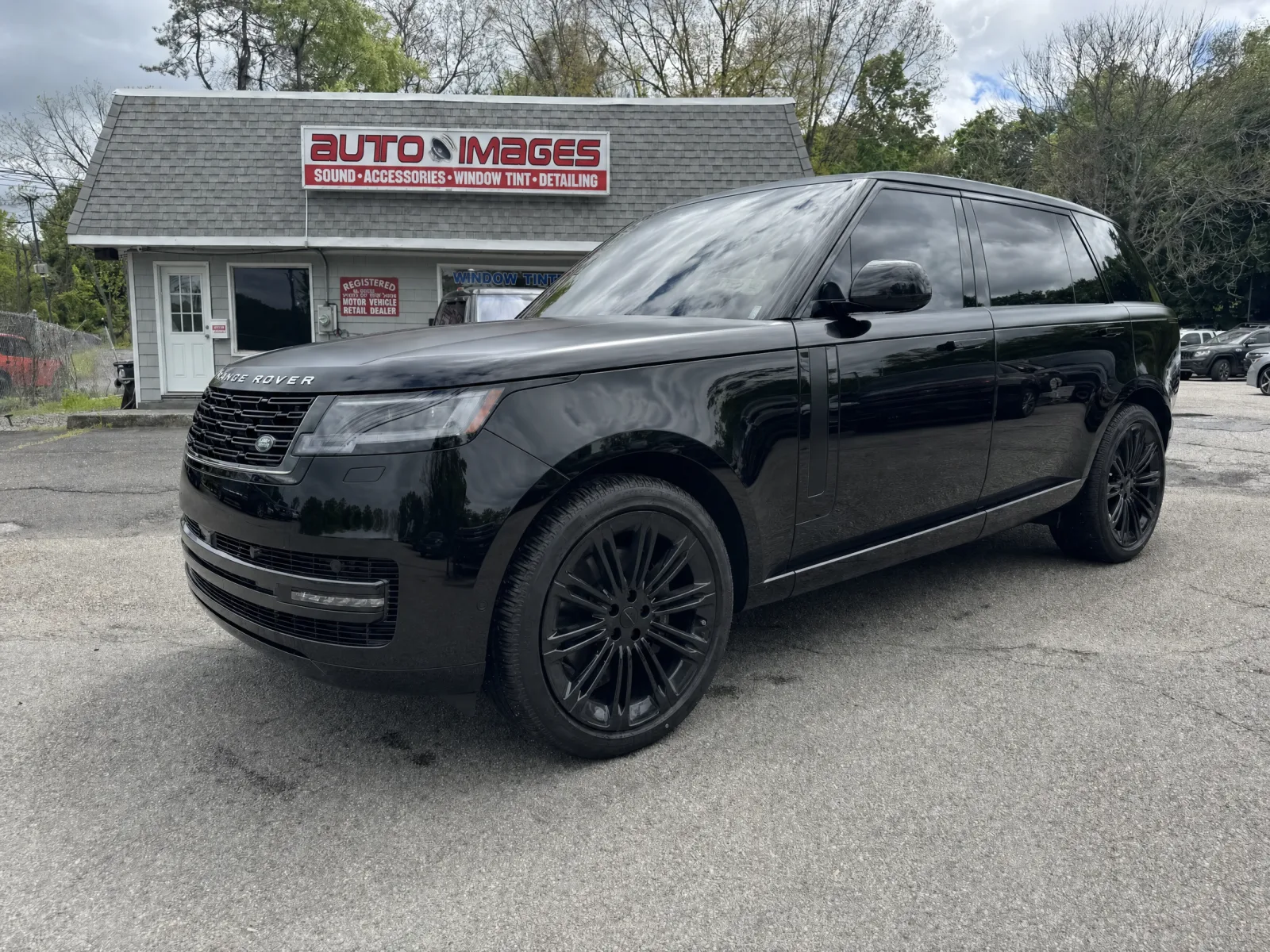 Range Rover in factory gloss black paint before wrapping, parked at the Auto Images storefront