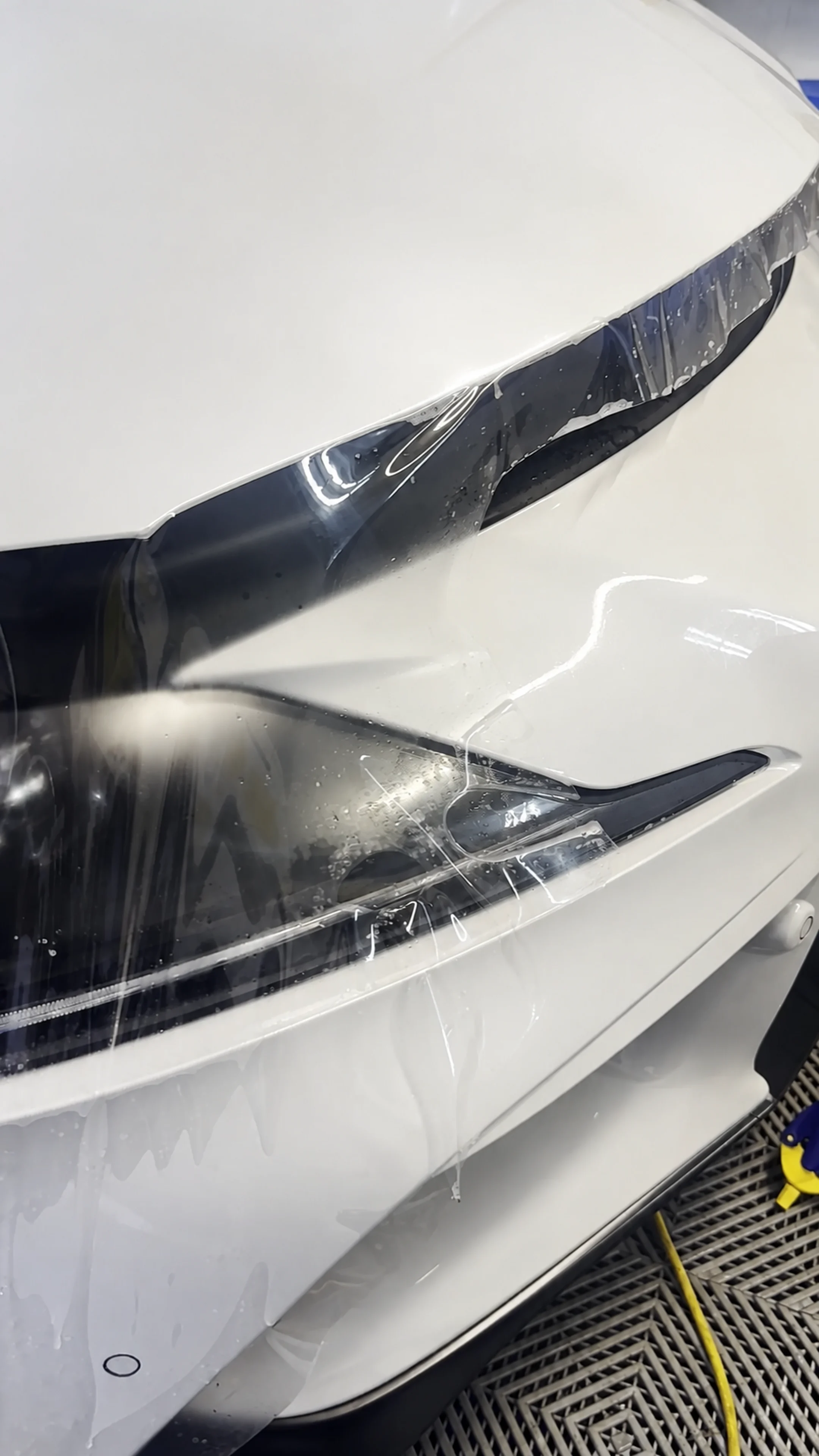 Clear paint protection film being fitted around a headlight