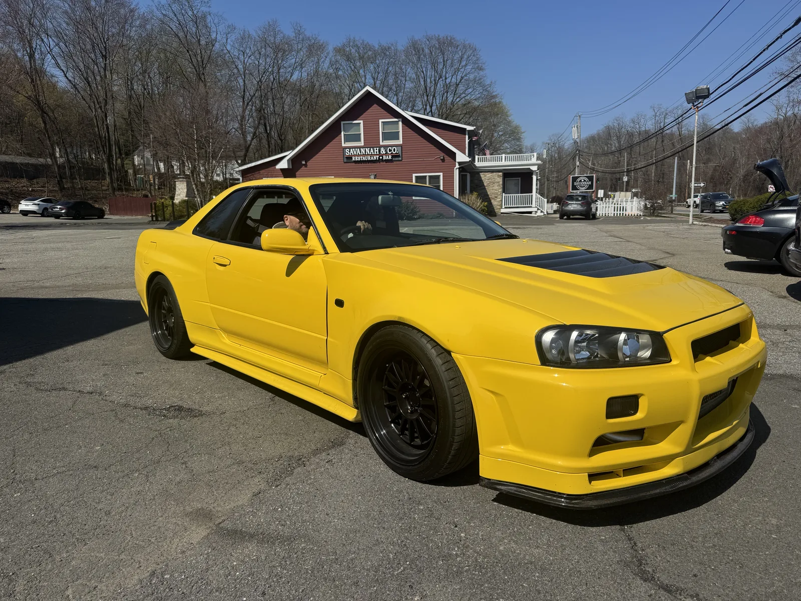 Yellow R34 Nissan Skyline washed and finished, parked outside the shop